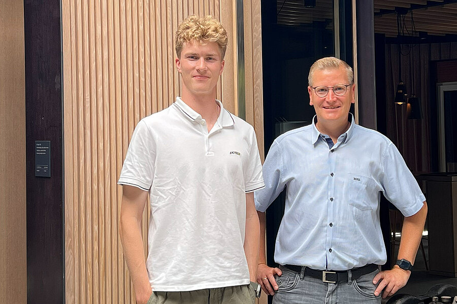 Linus Schmidt und Guido Kulhmann im Firmen-Ausstellungsraum vor einer Holztür