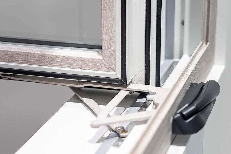 Der Flügel des Casement & Awning-Fensters wird durch zwei Bedien-Elemente fest an den Rahmen gezogen und verschlossen.